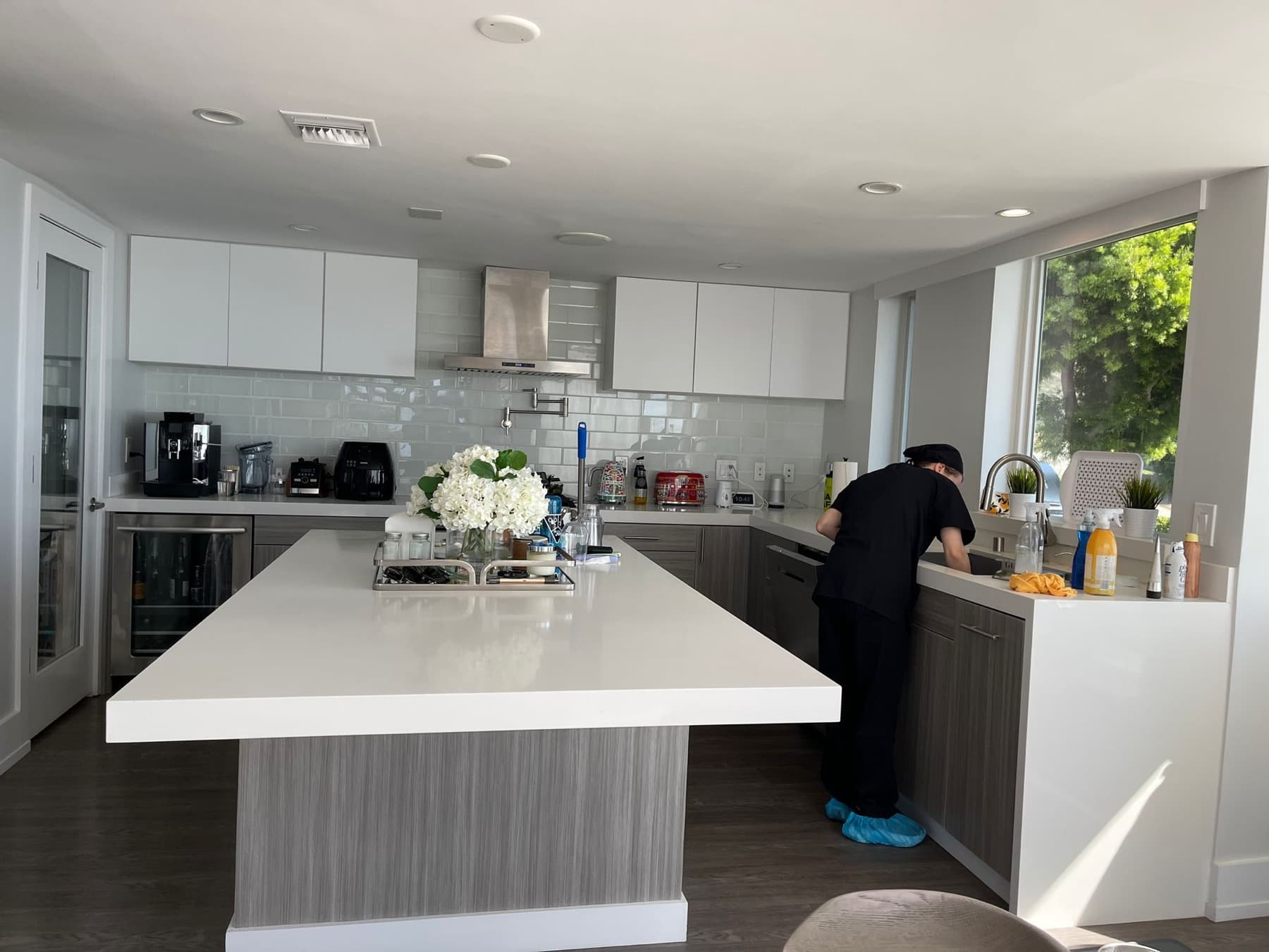 Team member cleaning a bright modern kitchen